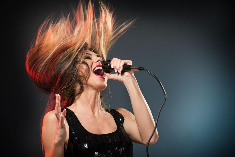 用麦克风唱歌的年轻女子