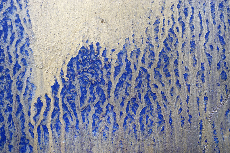 蓝色金属门上喷洒白色油漆的抽象背景特写