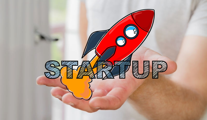 商人手持手绘启动文本和红色火箭概念