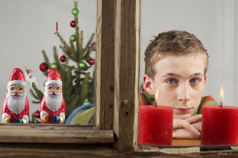 趴在窗户上的男孩看着两只红蜡烛