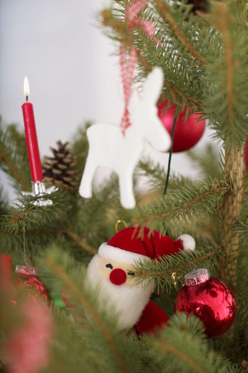 圣诞树上的装饰品和一根点燃的蜡烛