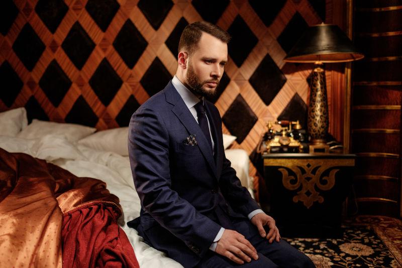 坐在床上成熟稳重的男商人