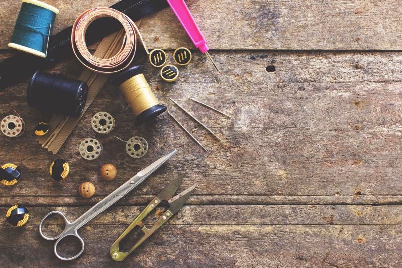 老旧木板上的剪刀针线顶针和软尺等缝纫工具
