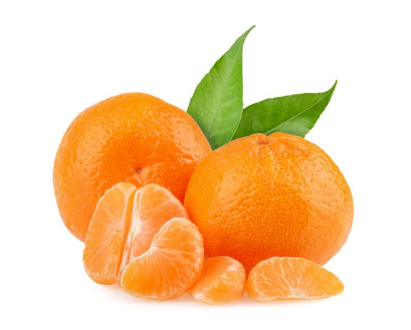 在白色背景下带绿叶的新鲜橘子