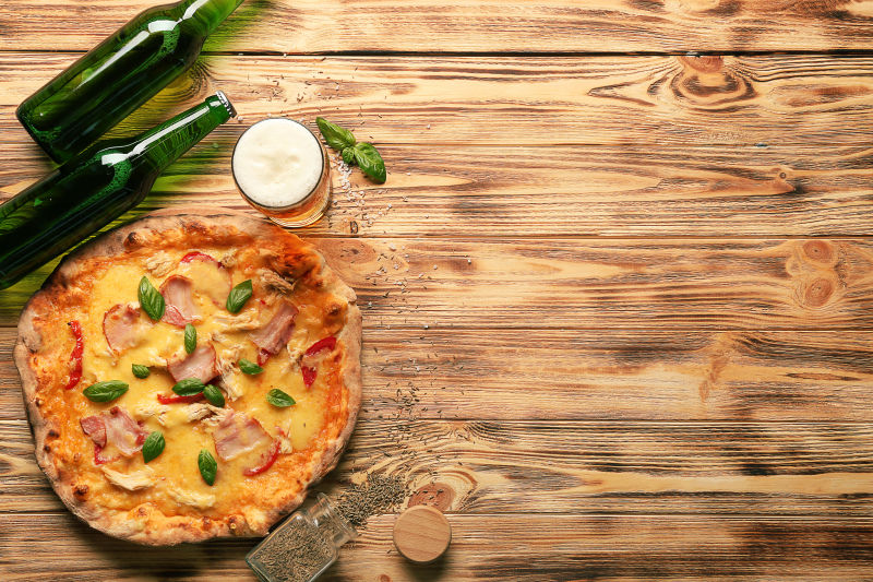 木桌上的比萨与啤酒