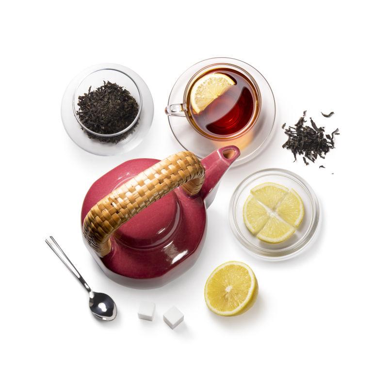 白色背景上的红茶和柠檬还有各种茶具