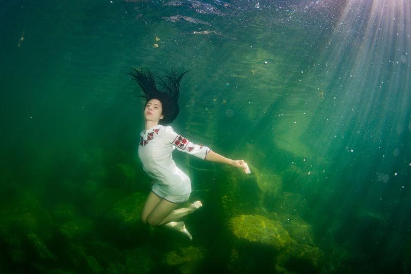 穿着乌克兰刺绣水下装扮的年轻优雅的女子在水中