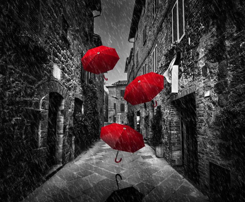 意大利托斯卡纳一个古老的意大利小镇的黑暗狭窄街道上的雨伞