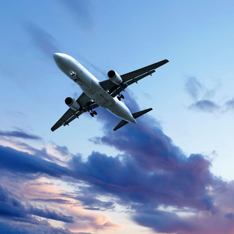 黄昏时分有火烧云的天空中的飞机