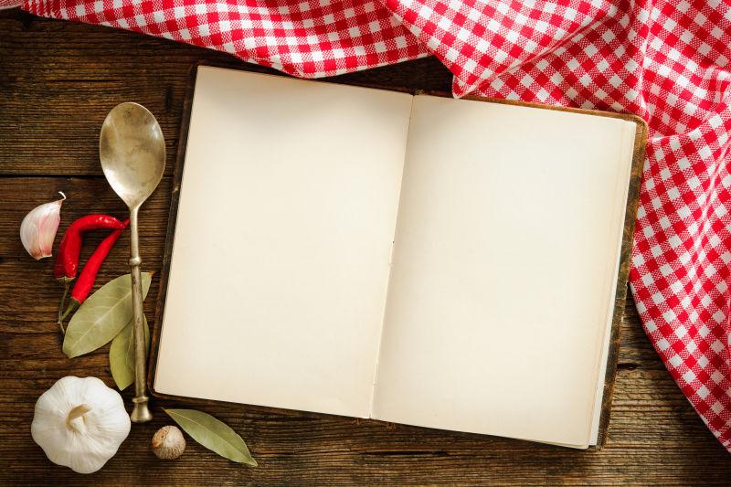 木桌上的红色格子台布空白的食谱和餐具