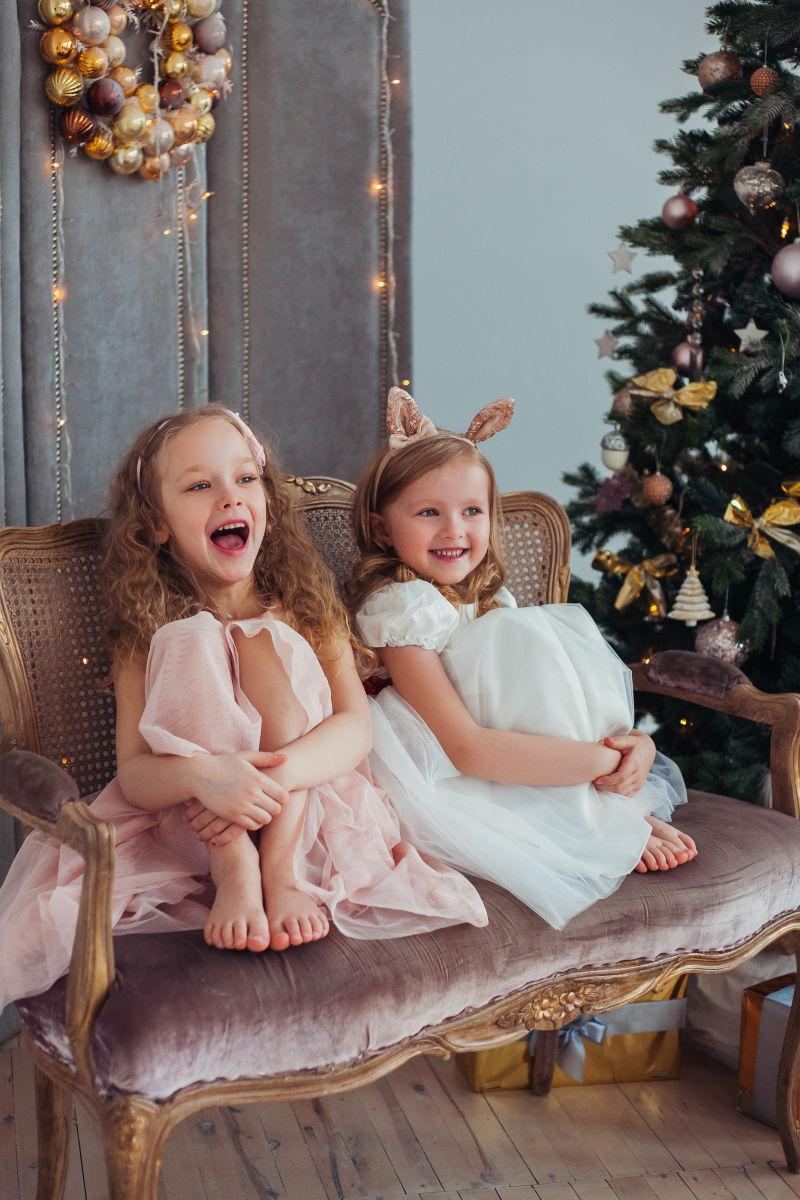 坐在圣诞树旁开心的小女孩