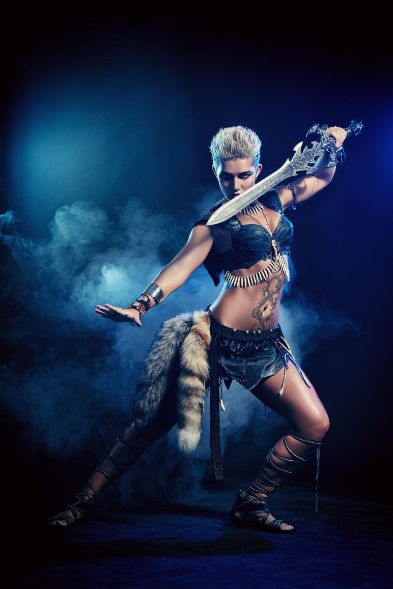 在蓝色烟雾中严肃的拿着宝剑战斗的女战士