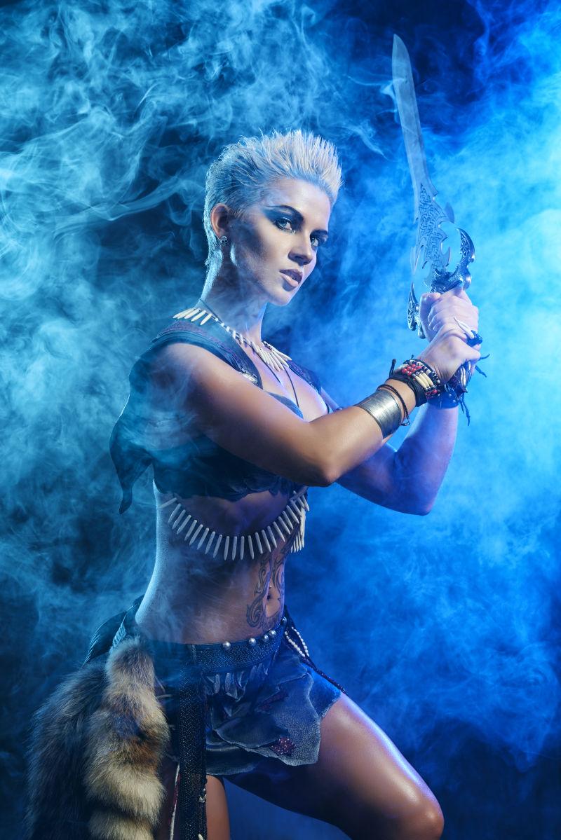 蓝色烟雾中拿着刀准备战斗的美女战士