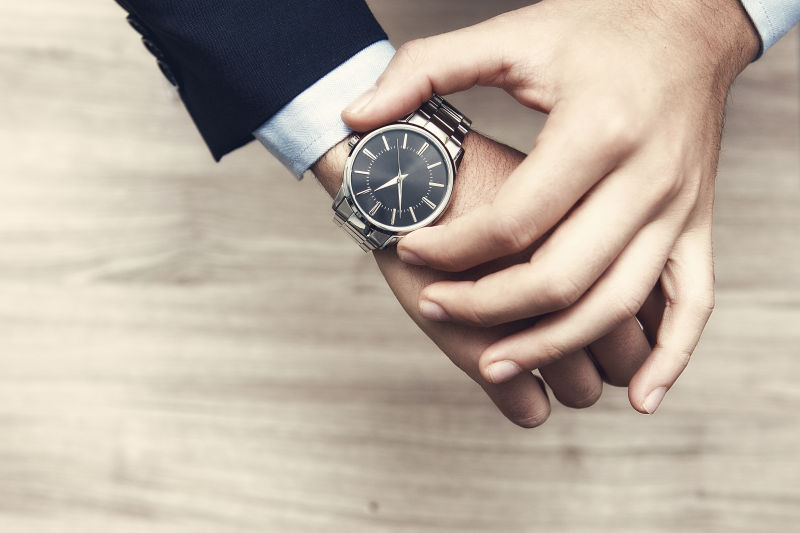 木桌背景下男人手上的手表