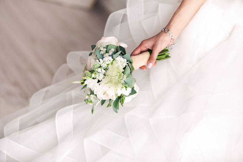 穿婚纱的新娘手拿花束