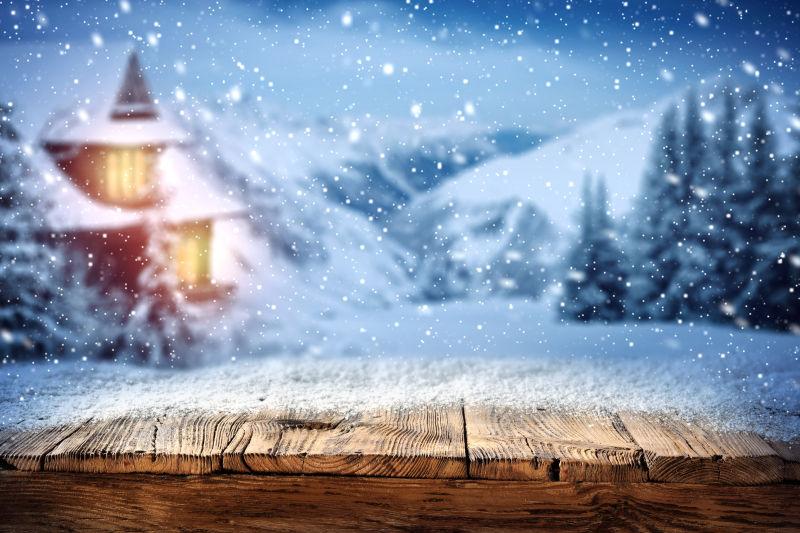 雪地里有灯光的房屋模糊背景和漫天的雪景