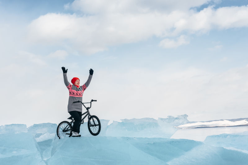 女孩举着双手在冰面上欢呼