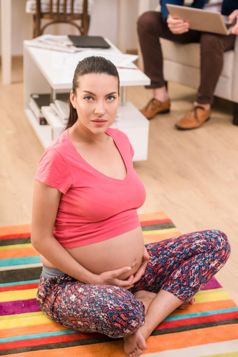 在瑜伽垫子上静坐的孕妇