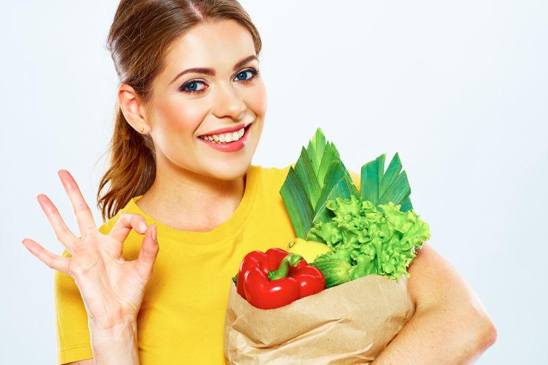 美女抱着一堆蔬菜比OK手势