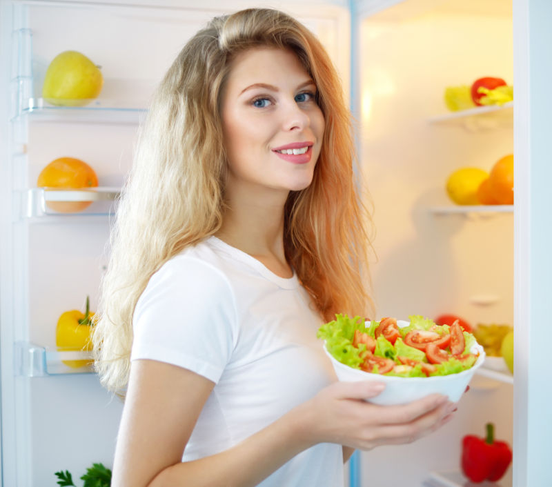 冰箱端出蔬菜的美女