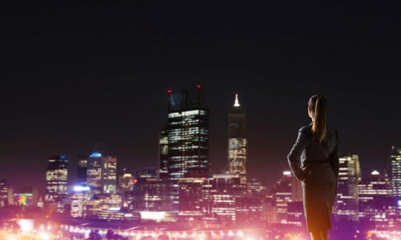 在高处眺望城市夜景的美女商人