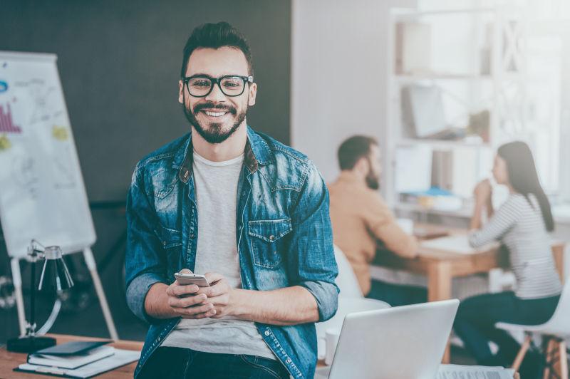 拿着智能手机微笑的男人