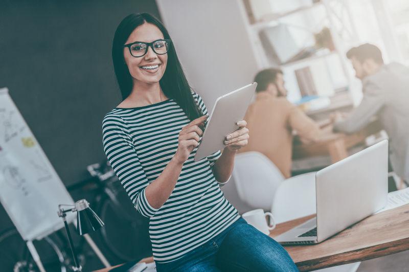 在办公室拿着平板电脑浏览的女人