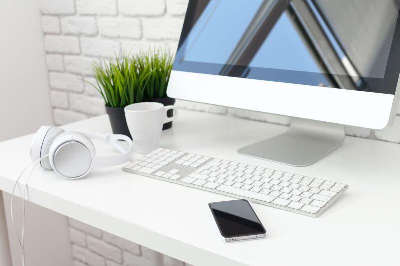 办公桌上的电脑咖啡杯还有手机