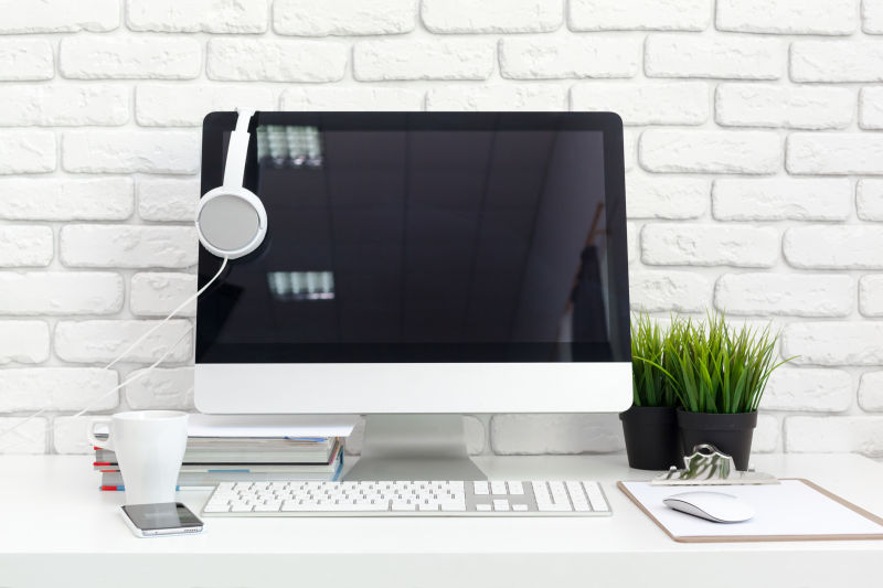 办公室里的办公桌上的有一台苹果电脑