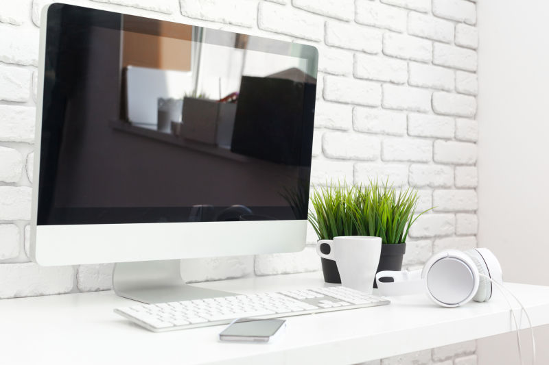 白色办公桌上的电脑咖啡杯还有一个手机