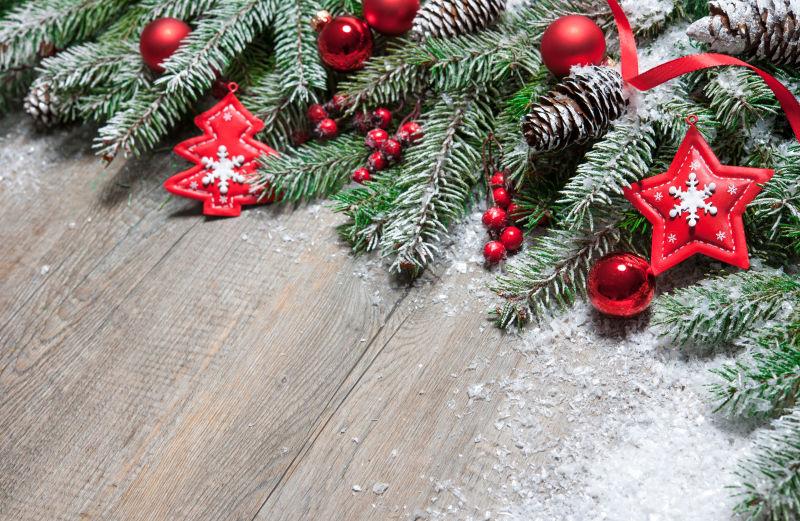 地板上的圣诞树枝上放着着各种红色的装饰品