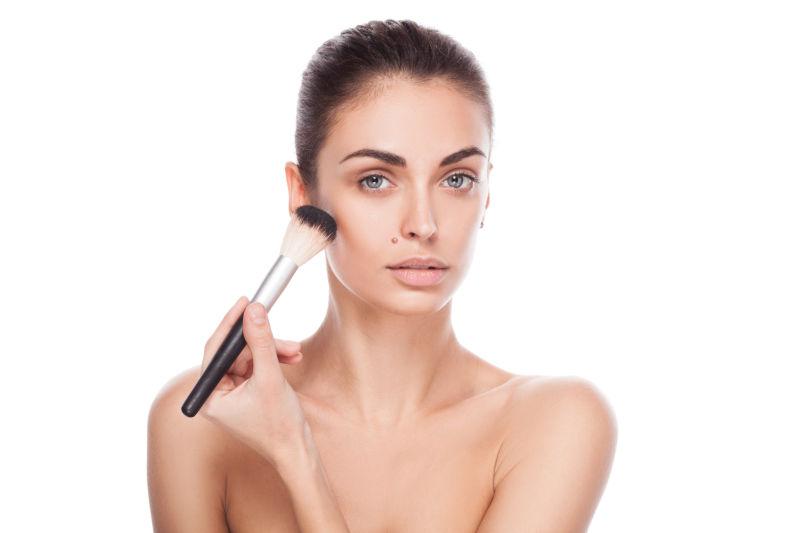 美女脸上有化妆刷的女人肖像