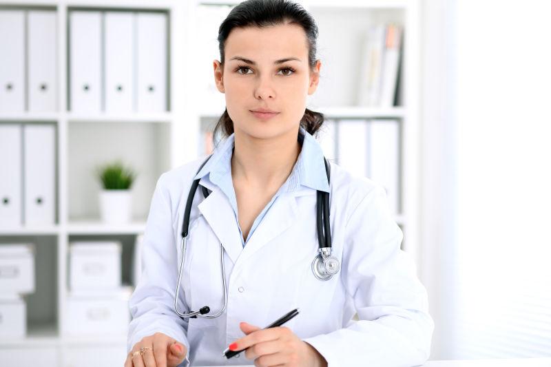 黑发女医生坐在靠近医院窗户的旁边