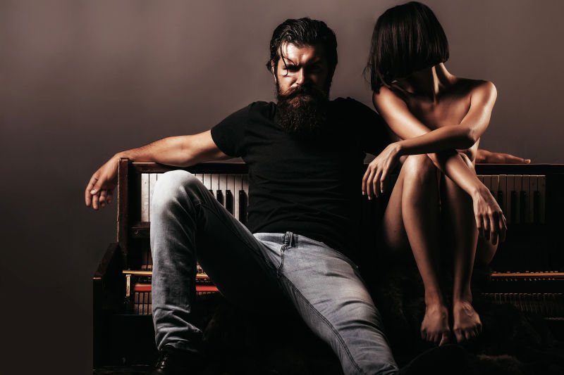 坐在钢琴上的年轻情侣