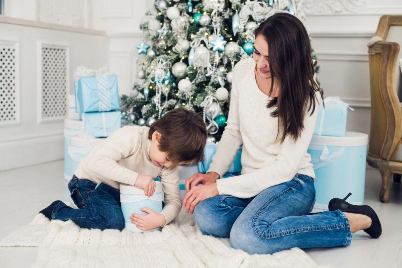 在圣诞树前拆礼物的母子