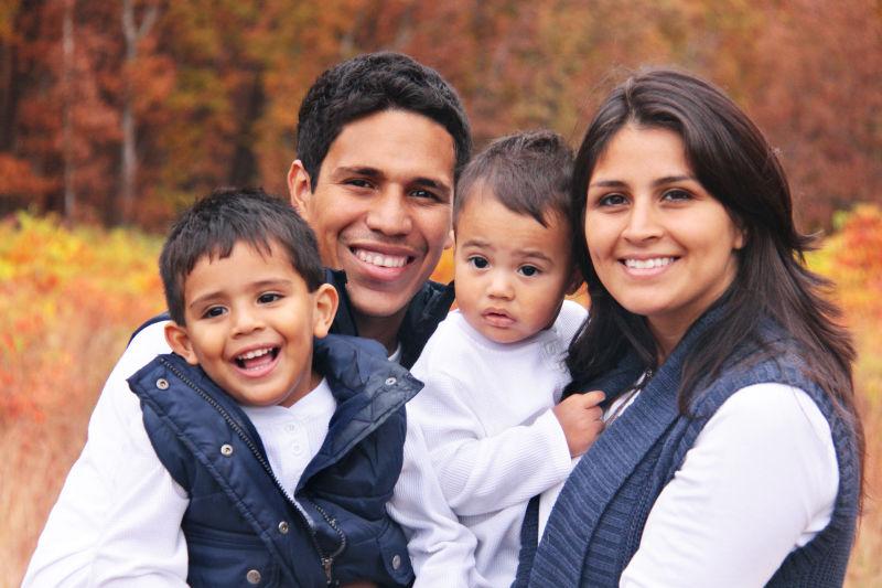 秋日黄色森林背景下开心微笑的一家人