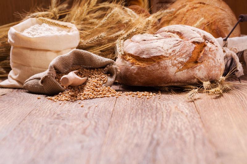 木板上新鲜的小麦面包玉米粒和面粉