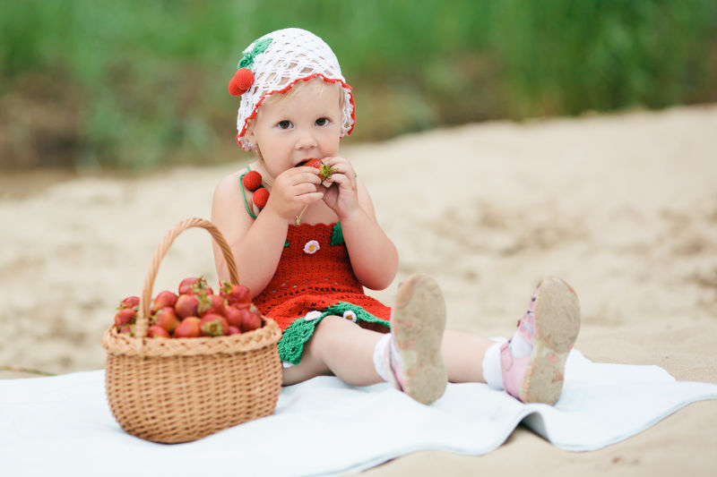 可爱的小女孩在吃草莓