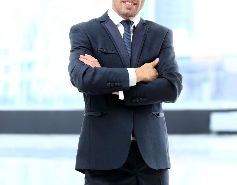 双手环胸的年轻西装商人