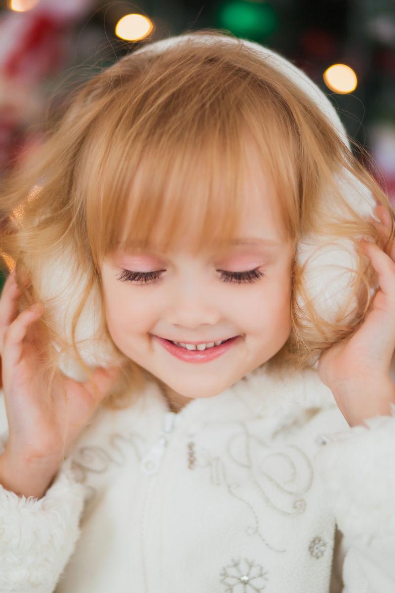 站在圣诞树旁的小美女