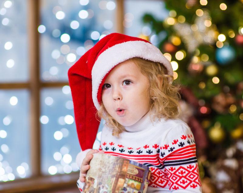带着圣诞帽惊讶表情的小女孩
