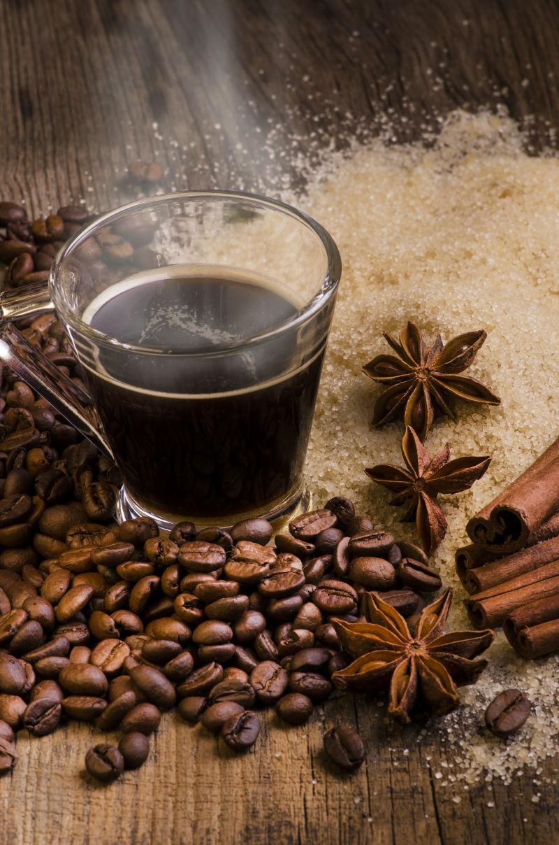 放在木板上冒着热气的咖啡咖啡豆和肉桂