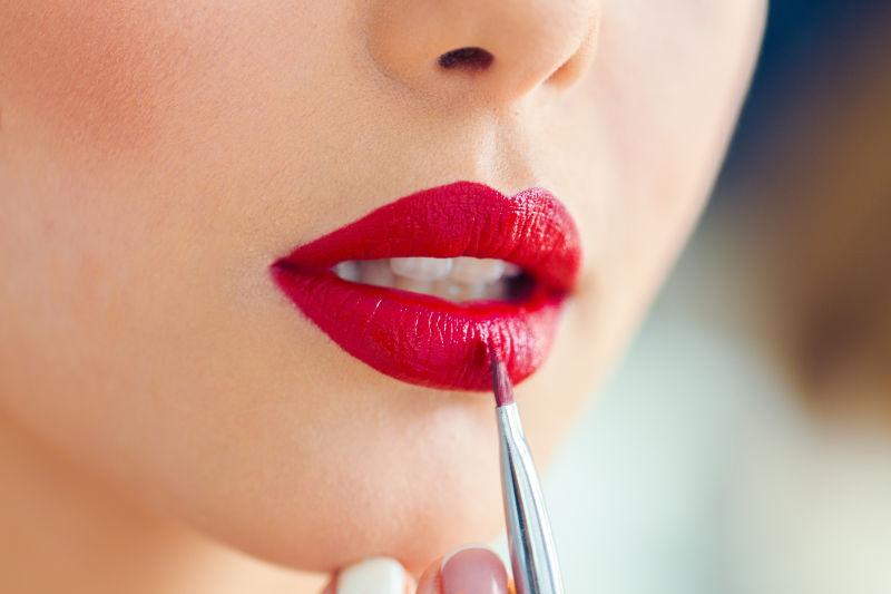 女子使用红色唇笔化妆