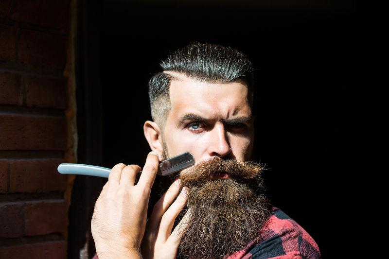 大胡子理发师拿着理发刀