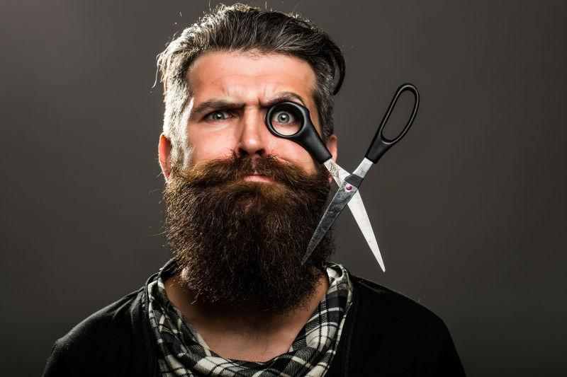 大胡子理发师眼睛上套着剪刀