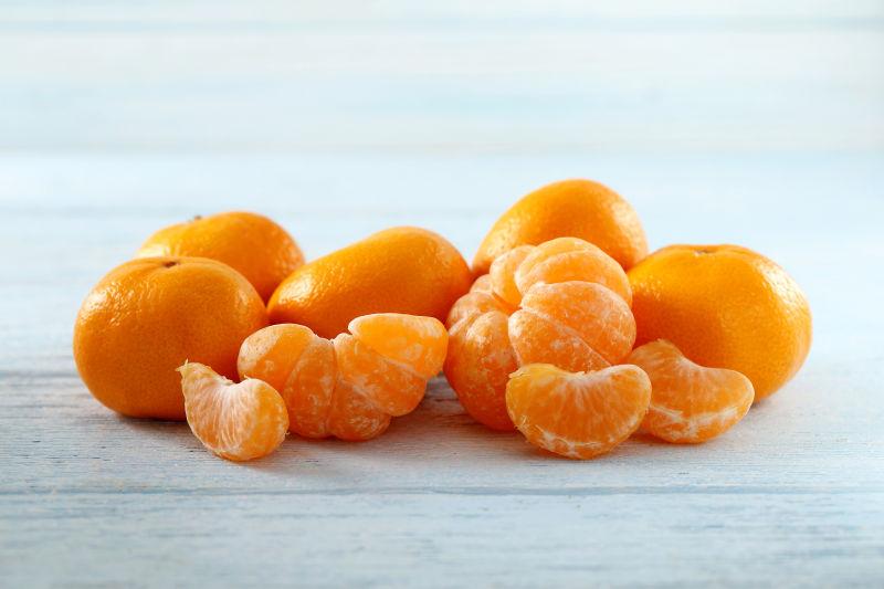 在蓝色木桌上成熟的去皮橘子