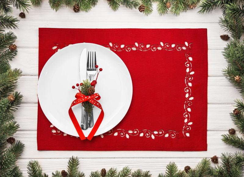 圣诞节冷杉树枝和盘子里的餐具
