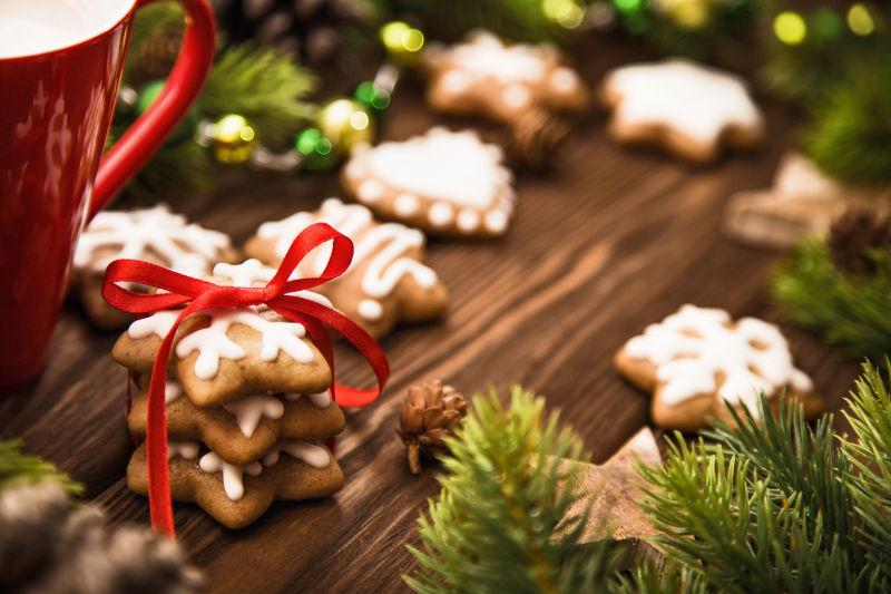 木制背景下的红丝带蝴蝶结圣诞饼干