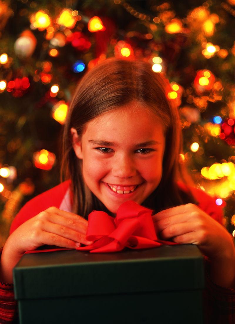 抱着圣诞礼物盒的外国小女孩