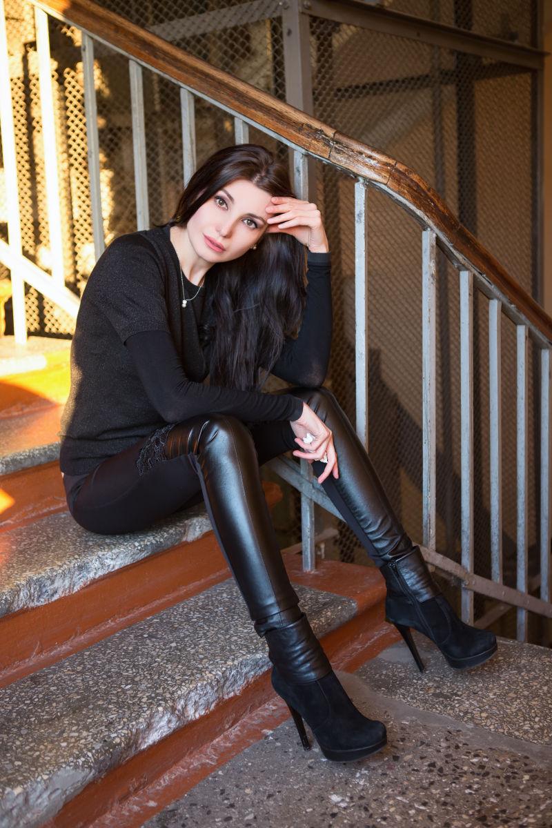 坐在楼梯上的性感年轻黑发女郎